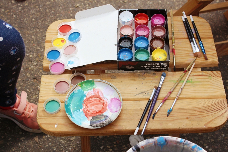 Un juego de pinturas y pinceles sobre una mesa de madera.