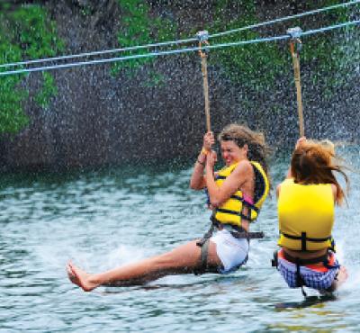 Girls ziplining across water at Brownstone Park