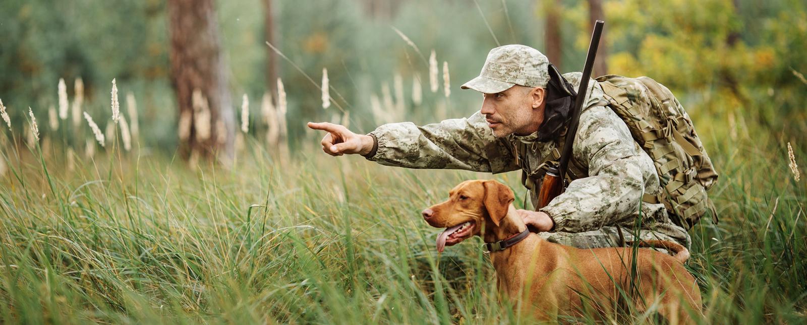 Hombre señalando la caza al perro