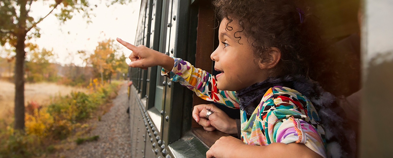 A girl looking out window of train