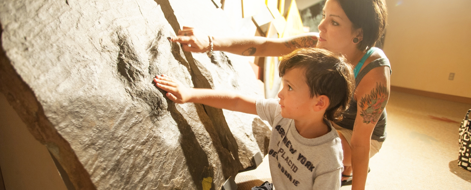 Mamá e hijo explorando huellas en Dinosaur State Park