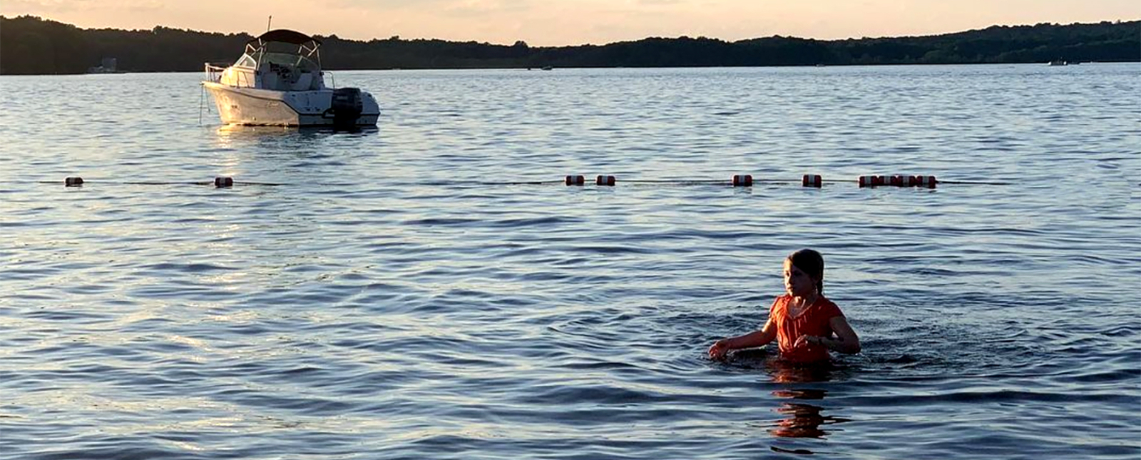 niña nadando en el lago con un barco al fondo (Instagram@sarateidee)