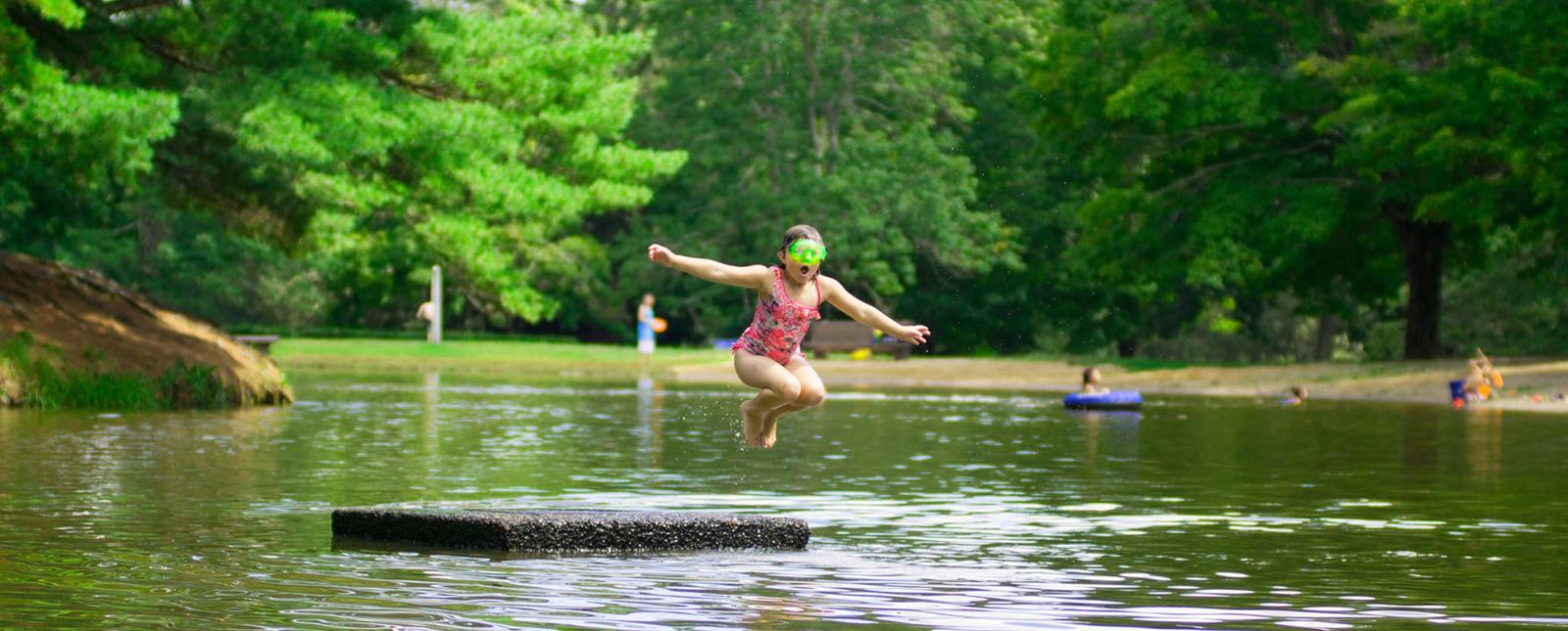 Girl jumping off dock at Mashamoquet Pond