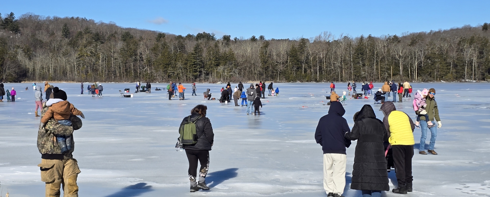 group of people walking on frozen pond