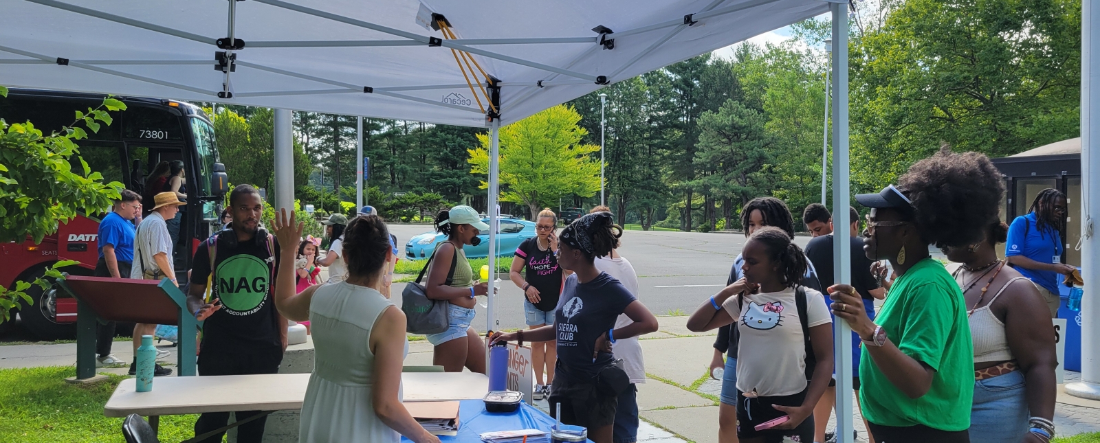 Grupo de personas de pie en una mesa/carpa de registro