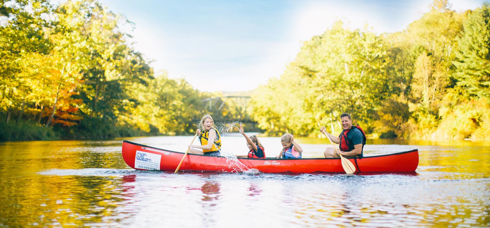 Familia de cuatro en canoa en el río Farmington