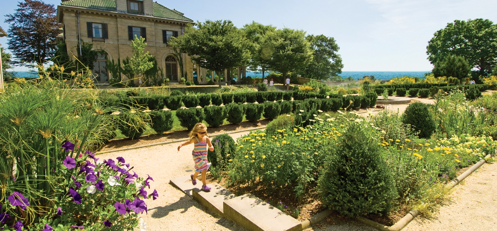 Niña corriendo frente a Harkness Mansion en Harkness Memorial State Park