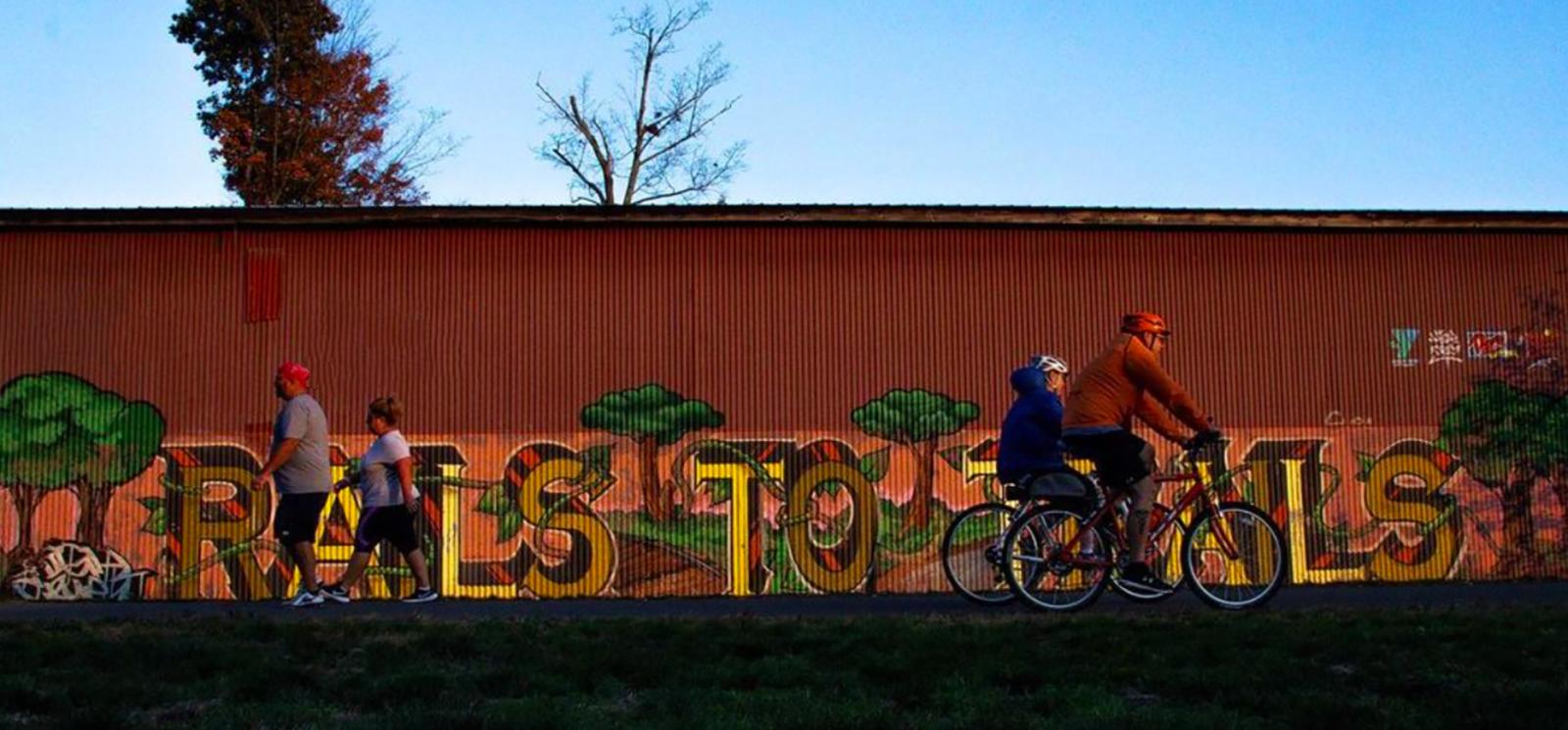 People walking and biking in front of mural (Instagram@aflaum)