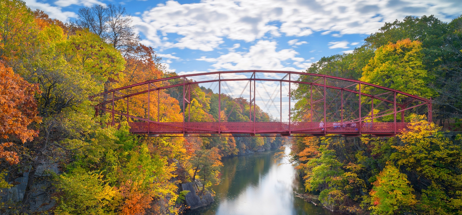 Una hermosa vista otoñal de un puente sobre un río (CTVisit)