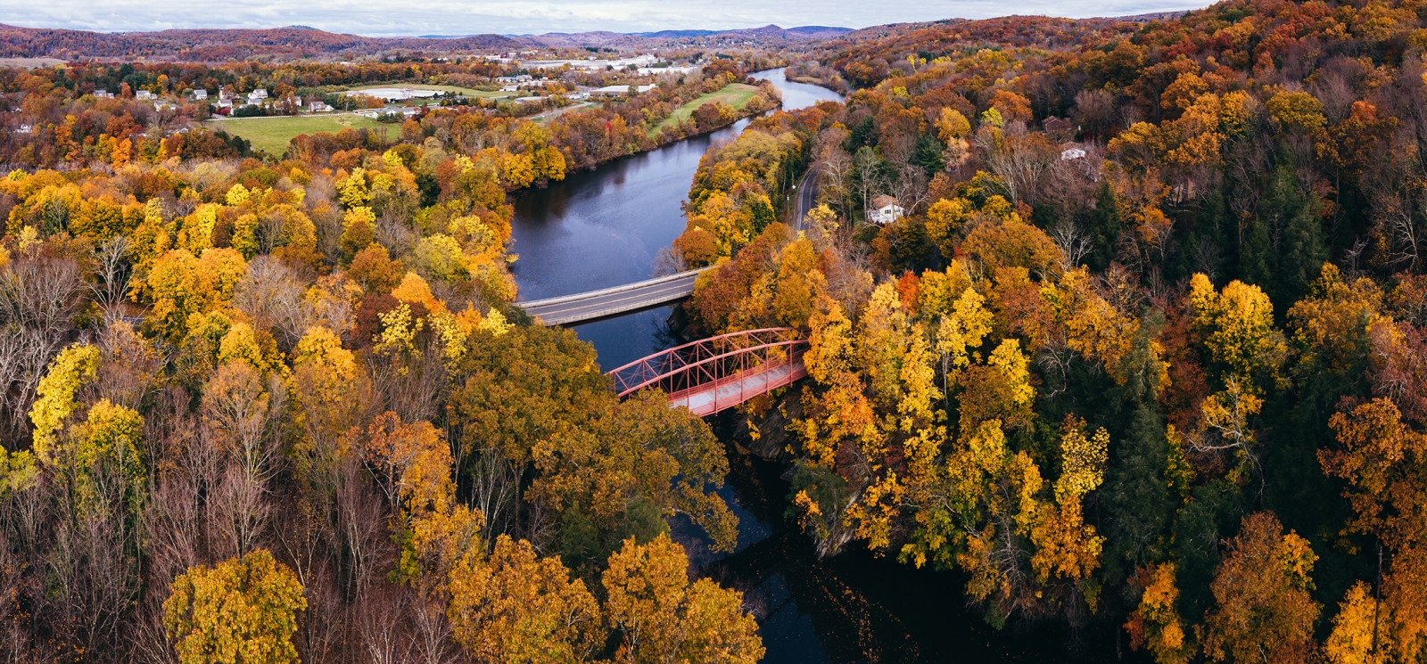 Vista aérea del follaje de otoño y el puente sobre un río (CTVisit)