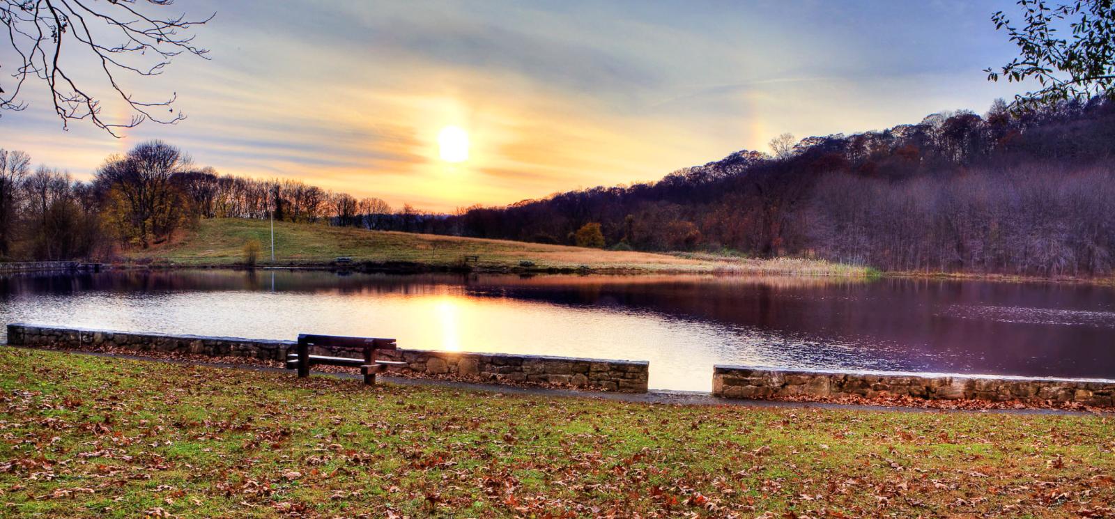 A sunset over the pond and fall leaves on the grass (Flickr@Sunday-Drive)