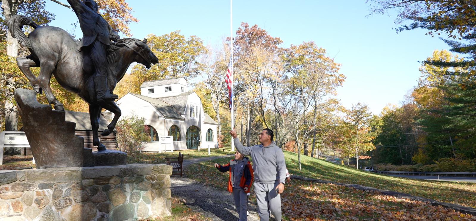 Padre e hijo explorando el Parque Estatal Putnam Memorial durante el otoño