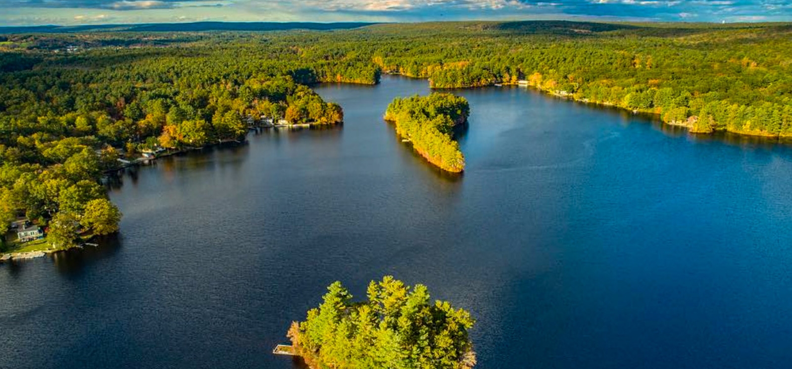 Un lago sereno ubicado en medio de una exuberante vegetación fotografiado desde arriba.