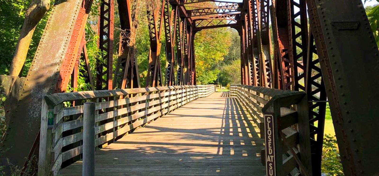 A bridge with a metal frame and a wooden walkway.