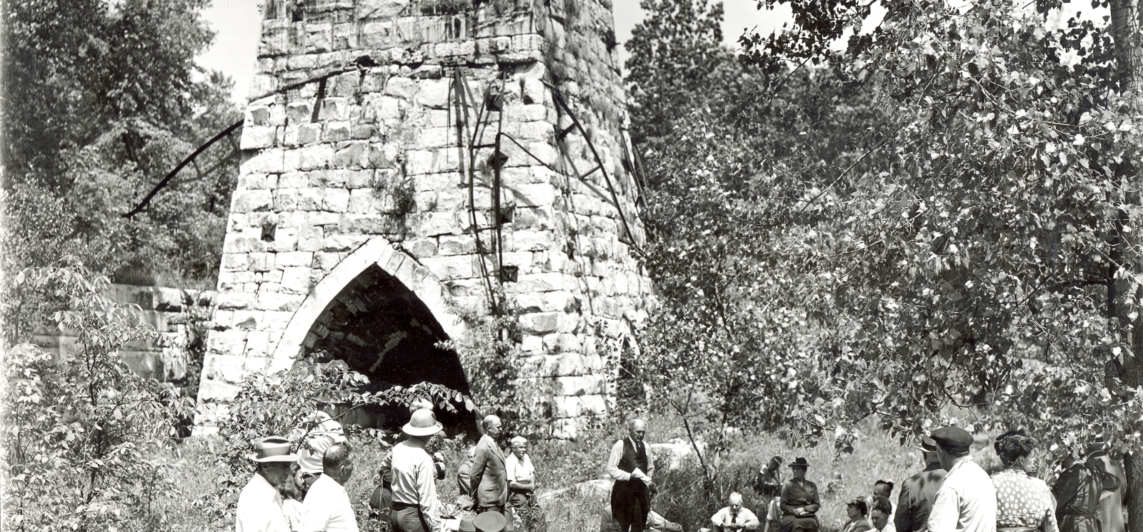 Black & white photo of Beckley Furnace with visitors in foreground