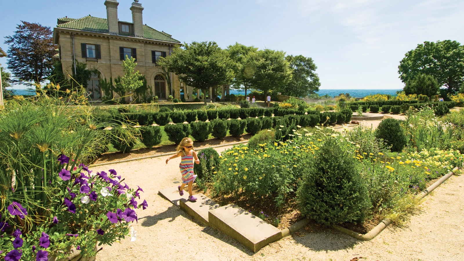 Young girl running in front of Harkness Mansion at Harkness Memorial State Park