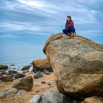 Woman sitting on rock at Hammonassett Beach