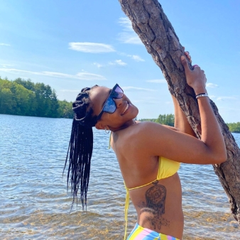 Una mujer en traje de baño sostiene un árbol cerca del agua (Instagram@marybaskerville10)