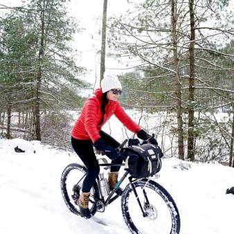A woman biking in the snow (Instagram@erinarie.gordon)
