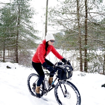 A woman biking in the snow (Instagram@erinarie.gordon)