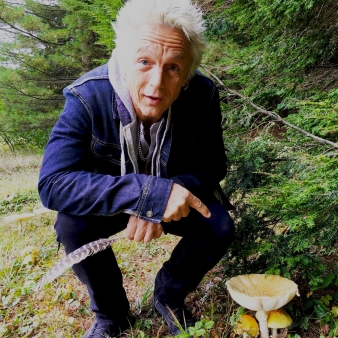 A man pointing at a mushroom in the woods (Instagram@theclownwrangler)