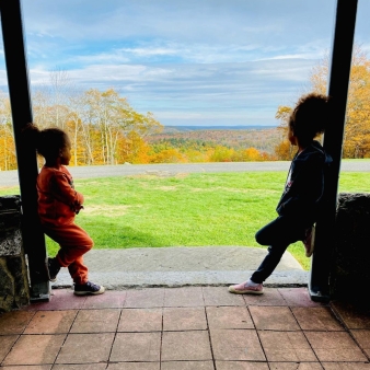 Dos niños apoyados frente a una agradable vista del paisaje otoñal (Instagram@tjuslivin)