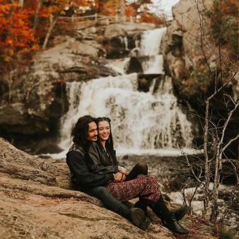 A couple sitting near a waterfall (Instagram@abigailreneephotography)