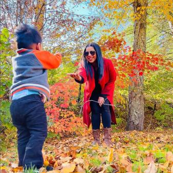 Mamá e hijo de pie en el follaje de otoño (Instagram@ashwinsgirl)