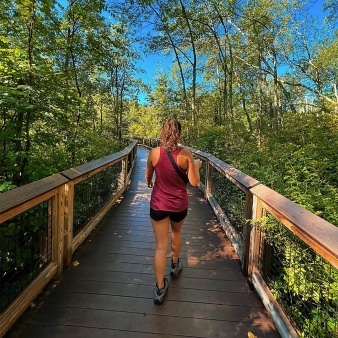 Woman walking along boardwalk trail at Dinosaur State Park (Instagram@shellypettopgraphy)