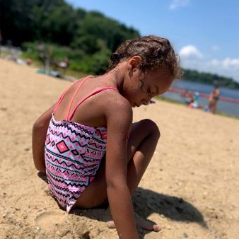 A child playing in the sand on the beach at Gardner Lake (Instagram@darren.bright.7)