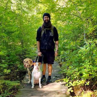 Un hombre con dos perros caminando por el bosque (Instagram@krigiz)