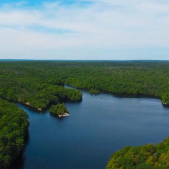 Una vista aérea del lago con árboles y cielo alrededor (Instagram@justinmiano)