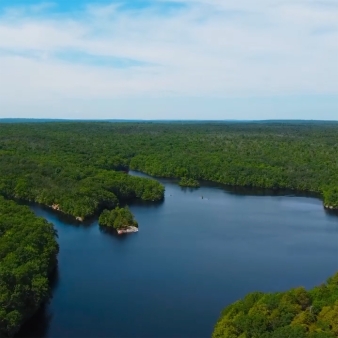 An aerial view of lake with surrounding trees and sky (Instagram@justinmiano)