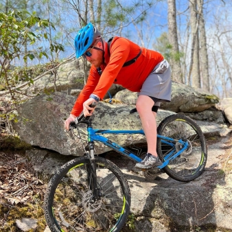 A man mountain biking over rocks in the woods (Instagram@sea12beast)