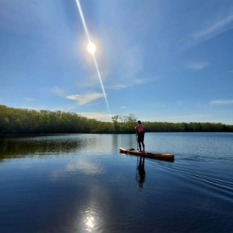 A man paddleboarding on a lake in the sun (Instagram@halfordcraig)