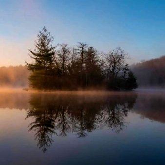 A misty sunset and an island of trees on the lake (Instagram@discoverne)