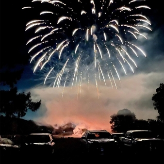 Cars parked with trees and fireworks in the background (Instagram@fin._photograph_ct)