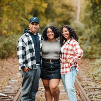 A family standing on railroad tracks in the woods (Instagram@carolinavillamizar)