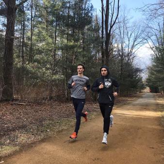 Two men running on path through the woods (Instagram@ericvanderels)