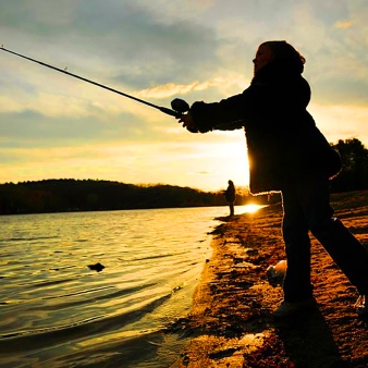 Mujer lanzando caña al estanque al atardecer en Hopeville Pond