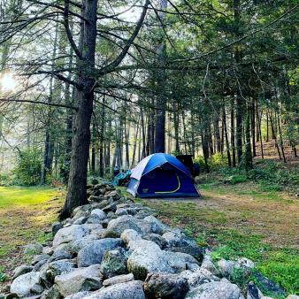 A campsite near a stone wall in the woods (Instagram@xiaosi2013)