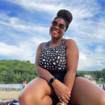 A woman in bathing suit poses for a picture at the beach (Instagram@naomiamoy)