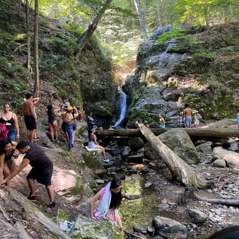 A group of people hiking and swimming near a waterfall (Instagram@allysha_ab_514_)