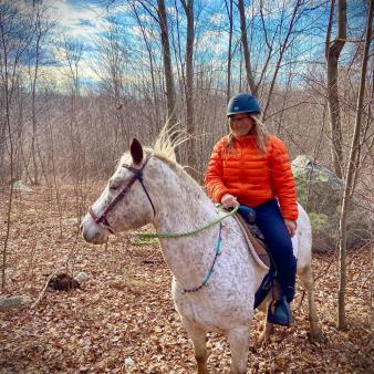 A woman rides a horse through the woods (Instagram@vikki_4ta)