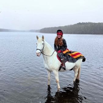 A woman rides a horse through the water in winter (Instagram@horseys)