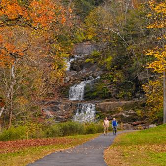 Couple walking along path at Kent Falls during peak foliage