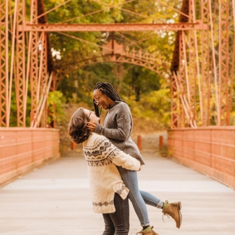 Una feliz pareja abrazándose en un puente (Instagram@alliedeari)