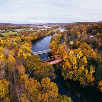 Aerial view of fall foliage and bridge over a river (CTVisit)