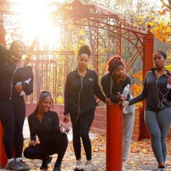 Teens pose for a photo in front of a bridge in the fall (Instagram@wcsu_wac)