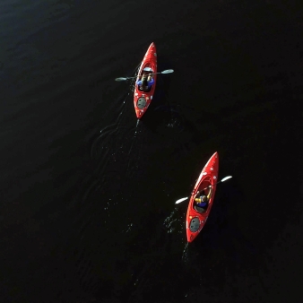 Una vista aérea de dos personas en kayak en aguas oscuras